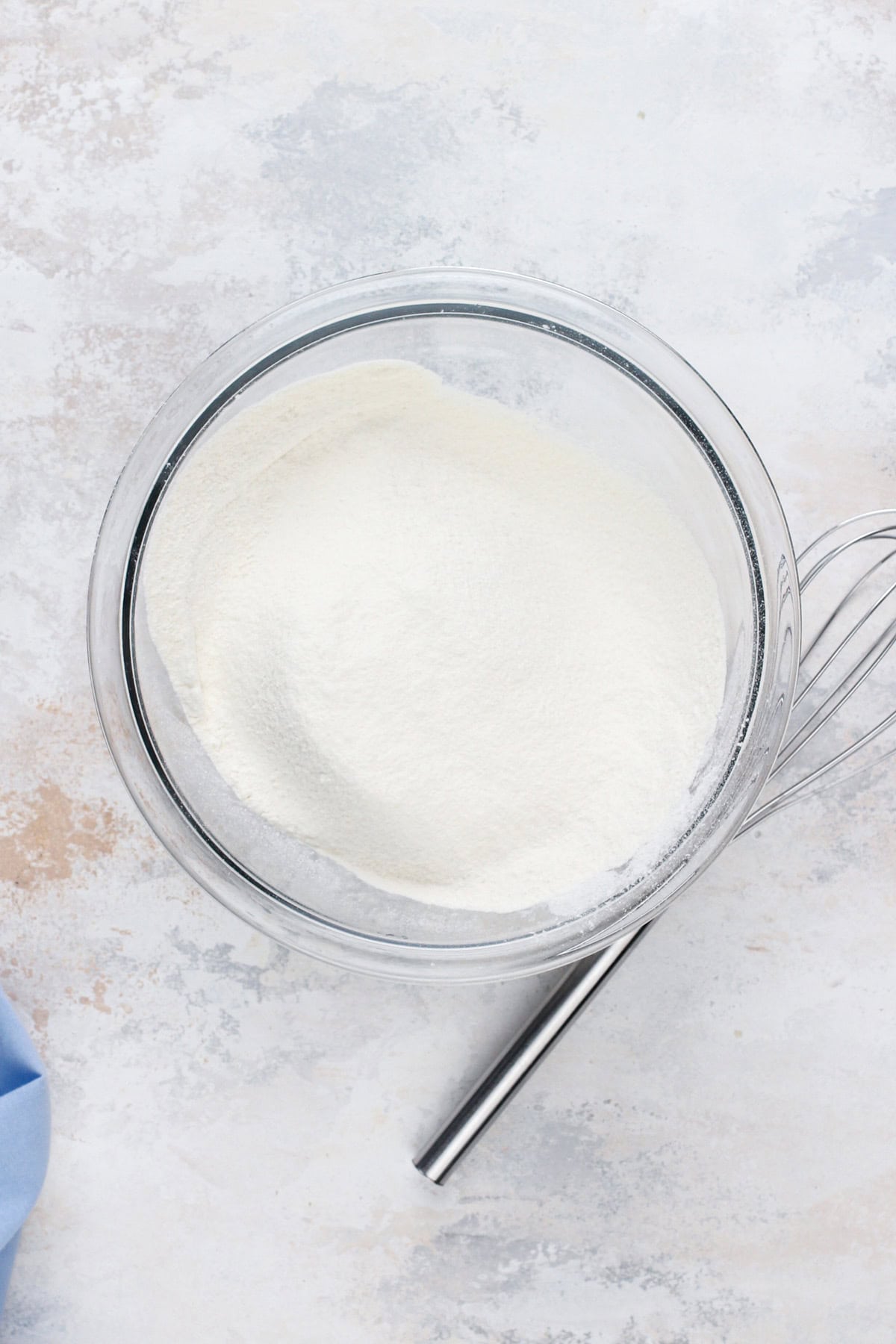 Dry ingredients for vanilla cake sifted in a white bowl.