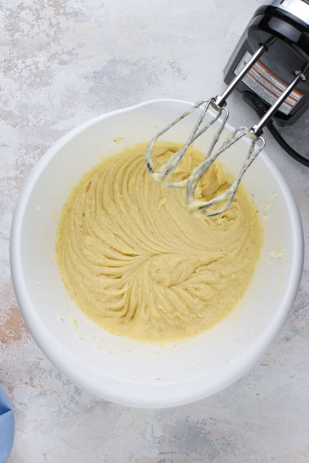 Wet ingredients for vanilla cake mixed together in a white bowl.