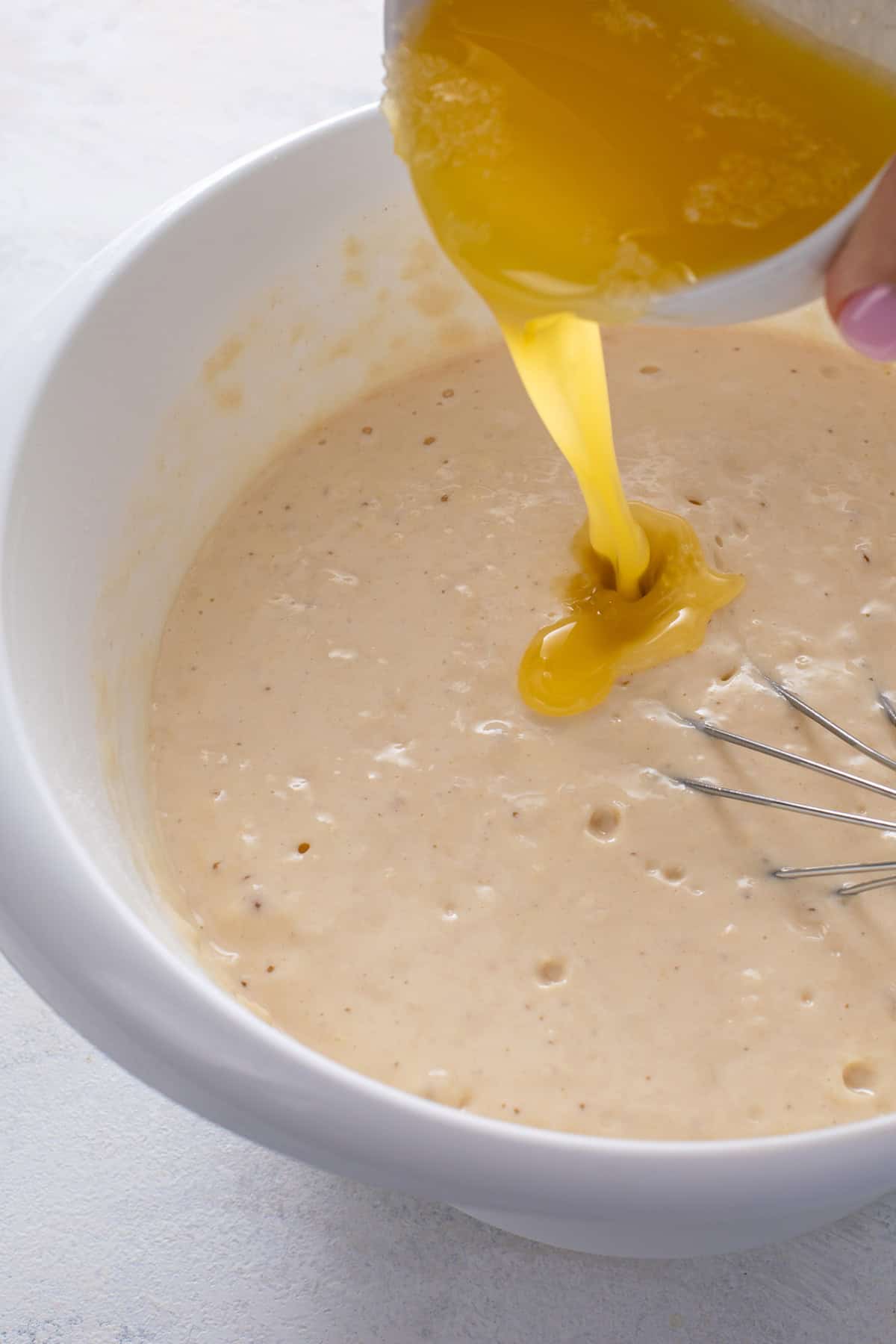 Melted butter being added to pancake batter.