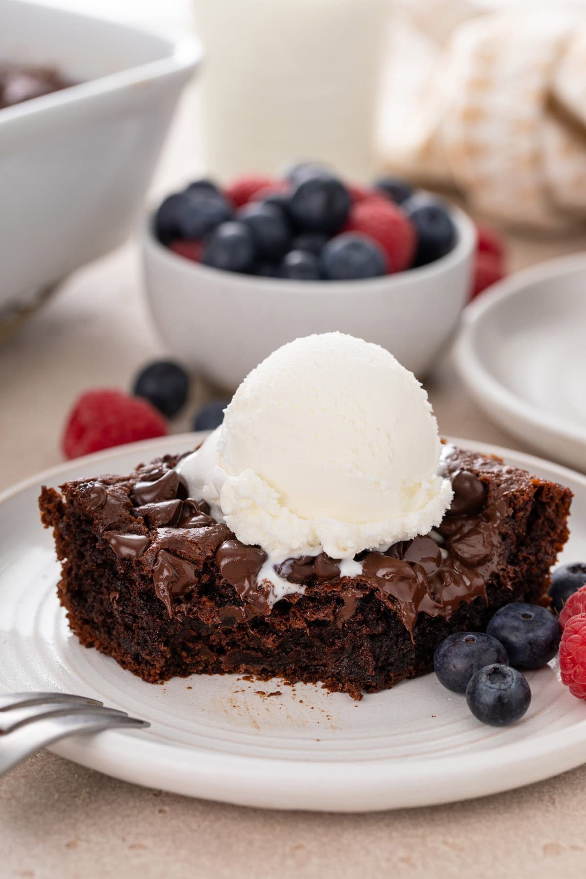 Bite taken from the corner of a slice of chocolate dump cake on a white plate.