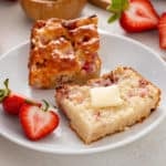 Plated halved strawberry biscuit topped with butter.