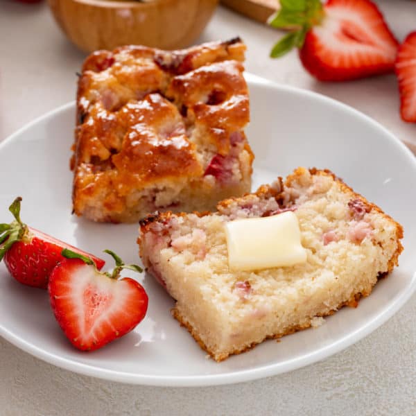 Plated halved strawberry biscuit topped with butter.