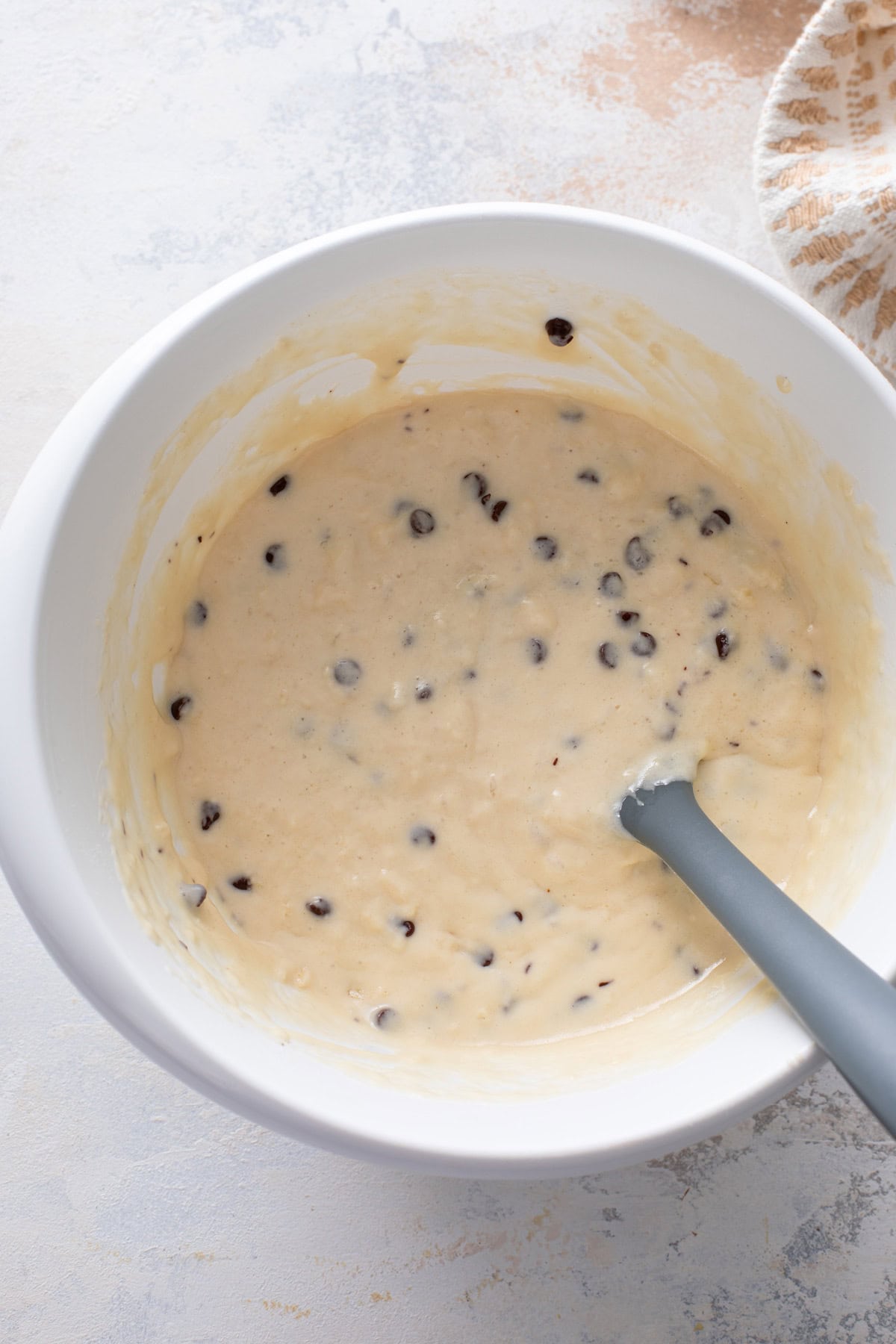 Chocolate chip pancake batter in a white bowl.
