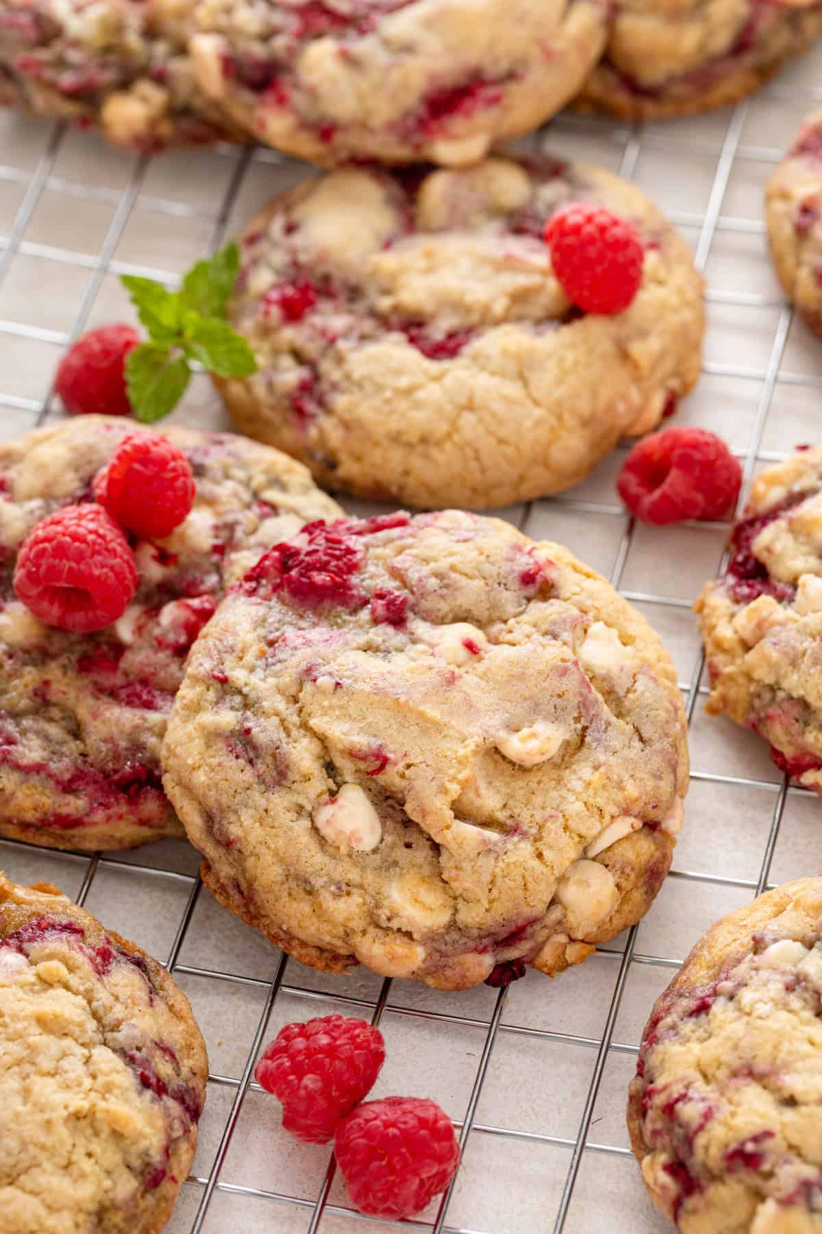 Close up image of white chocolate raspberry cookies on a wire rack.