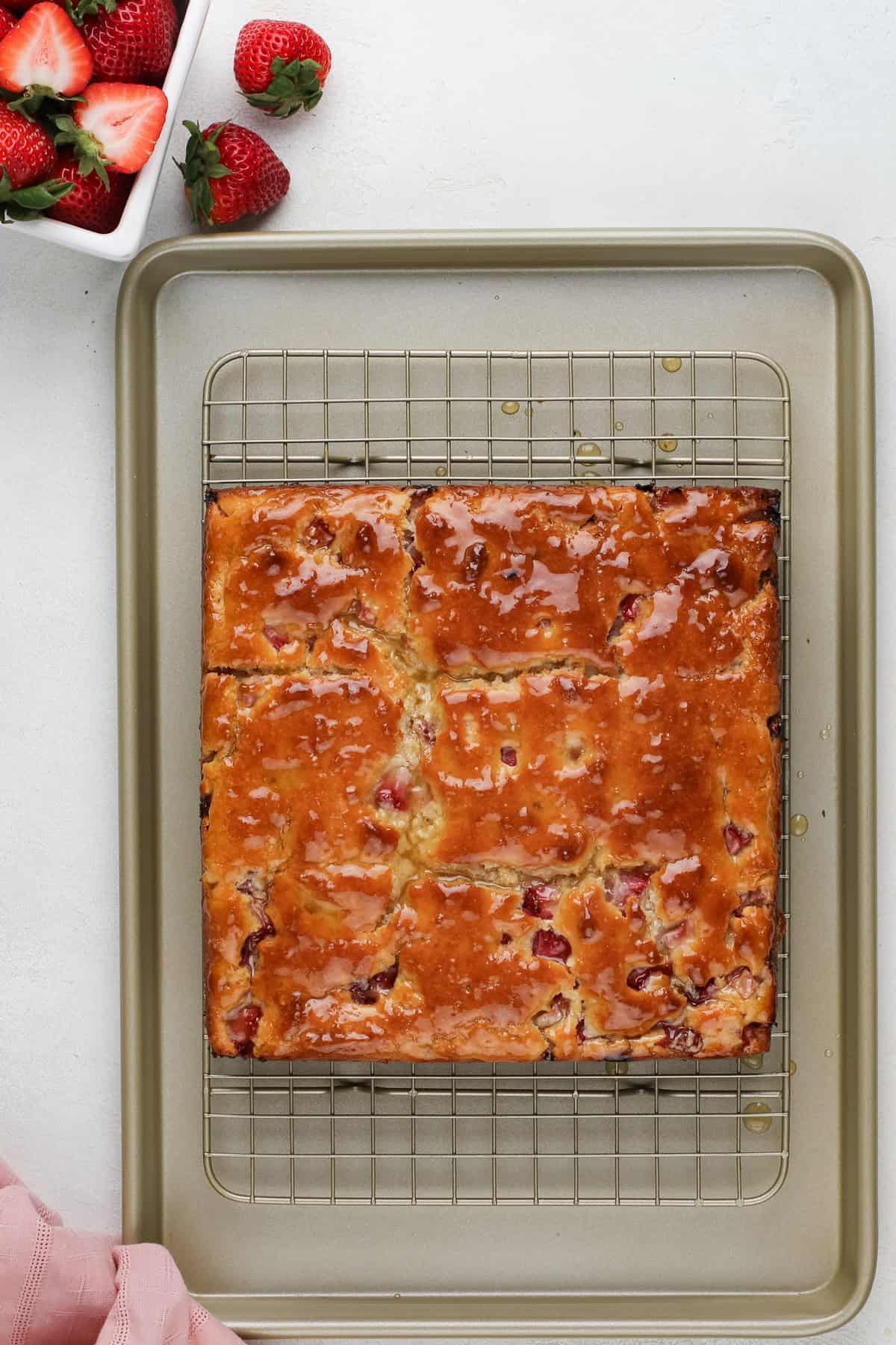 Cooling strawberry biscuits topped with honey butter on a wire rack.