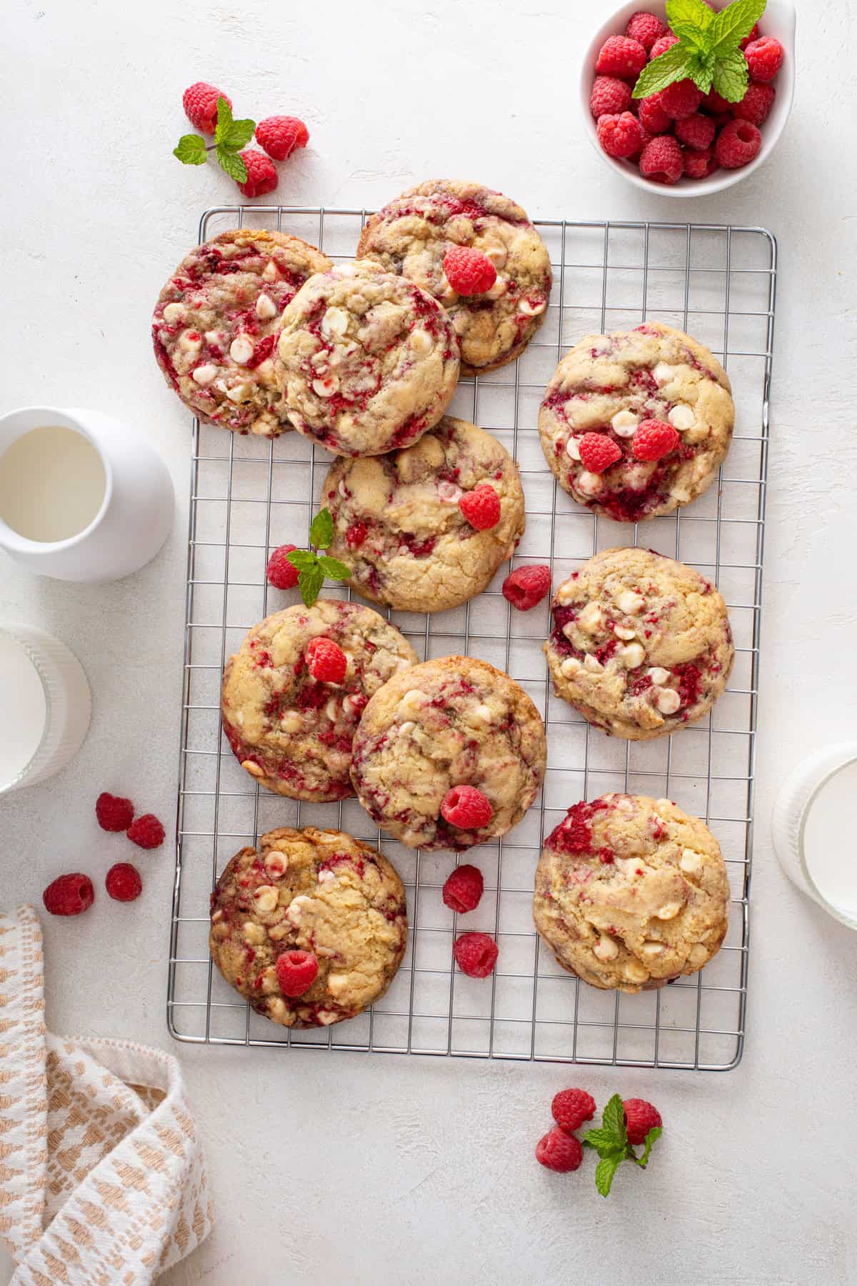 Overhead view of white chocolate raspberry cookies cooling on a wire rack.