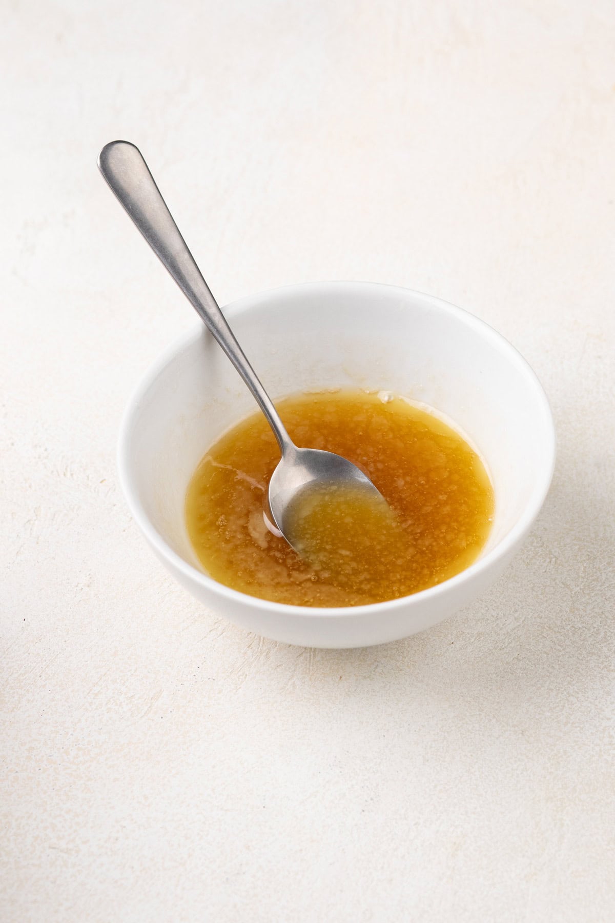 Melted honey butter in a white bowl.