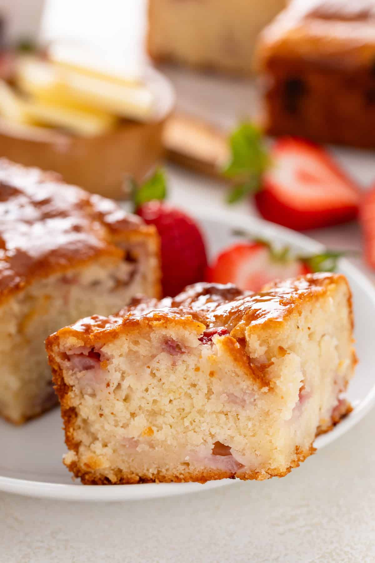 Strawberry biscuits and fresh strawberries on a white plate.