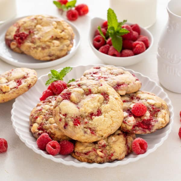 White plate filled with white chocolate raspberry cookies.