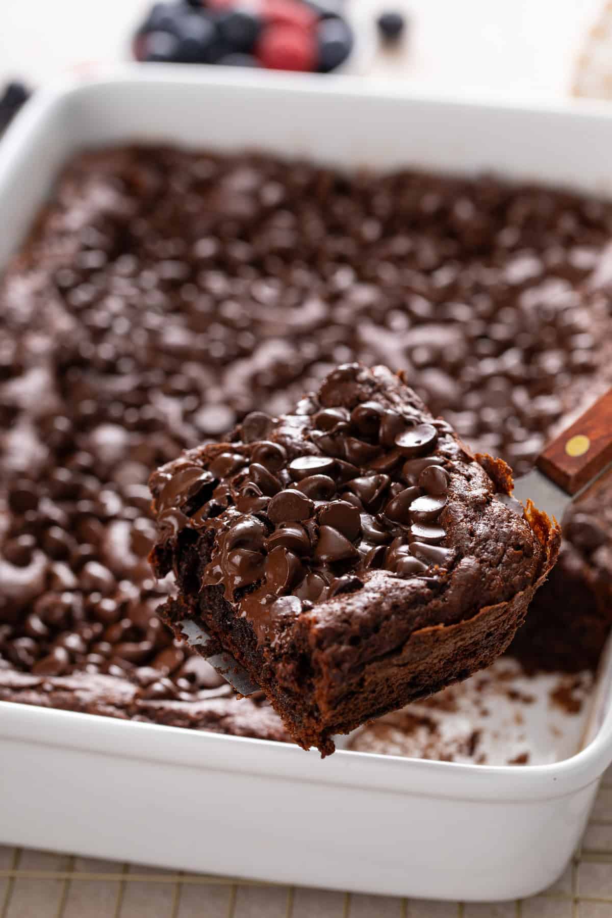 Cake server lifting a slice of chocolate dump cake up to the camera.