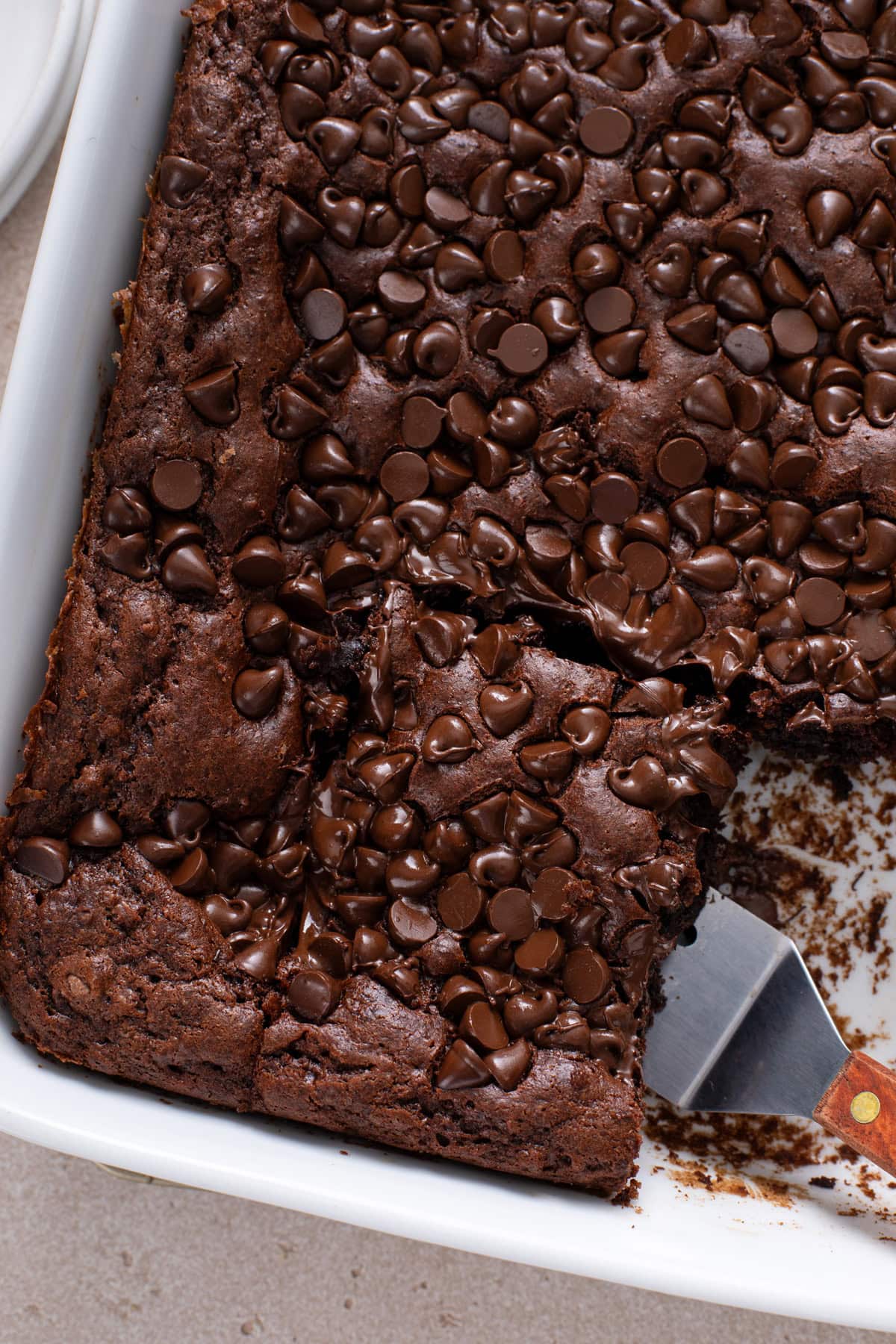 Sliced chocolate dump cake in a white baking dish.
