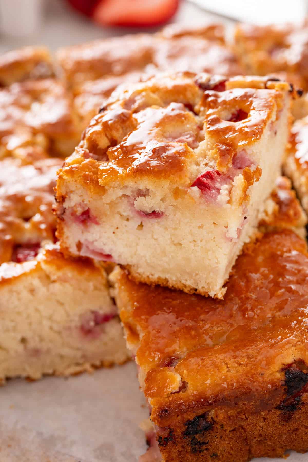 Strawberry biscuit stacked on top of the rest of the pan of the biscuits.