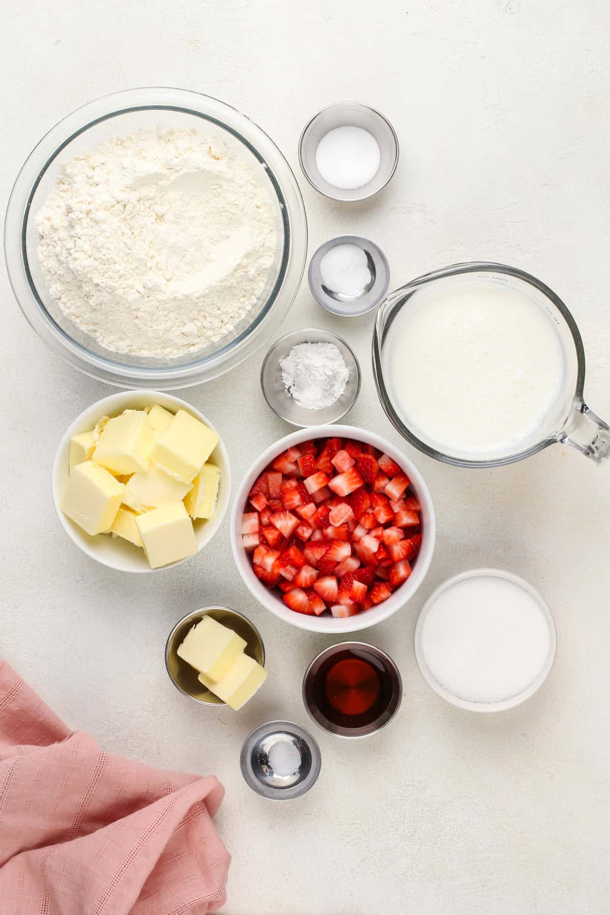 Strawberry biscuit ingredients arranged on a countertop.