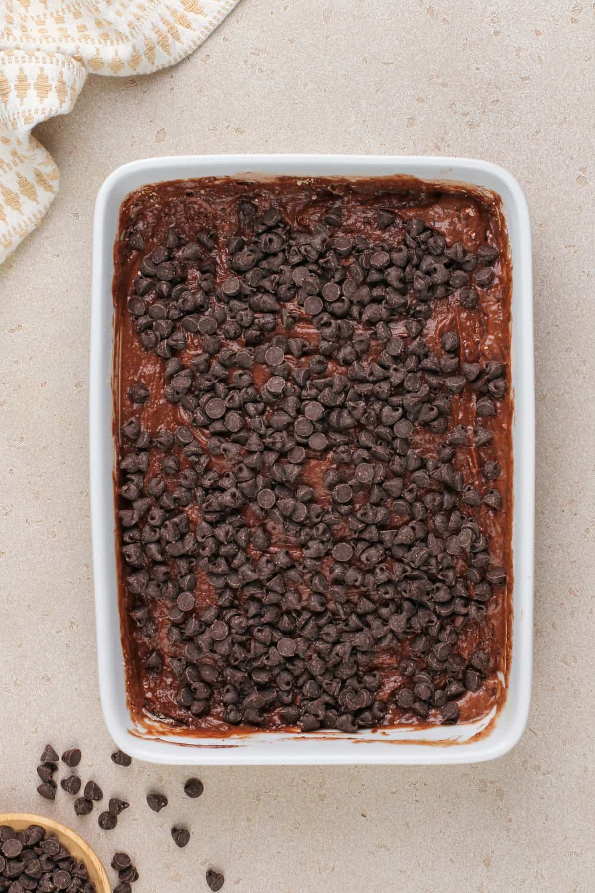 Assembled chocolate dump cake in a white baking dish, ready to go in the oven.