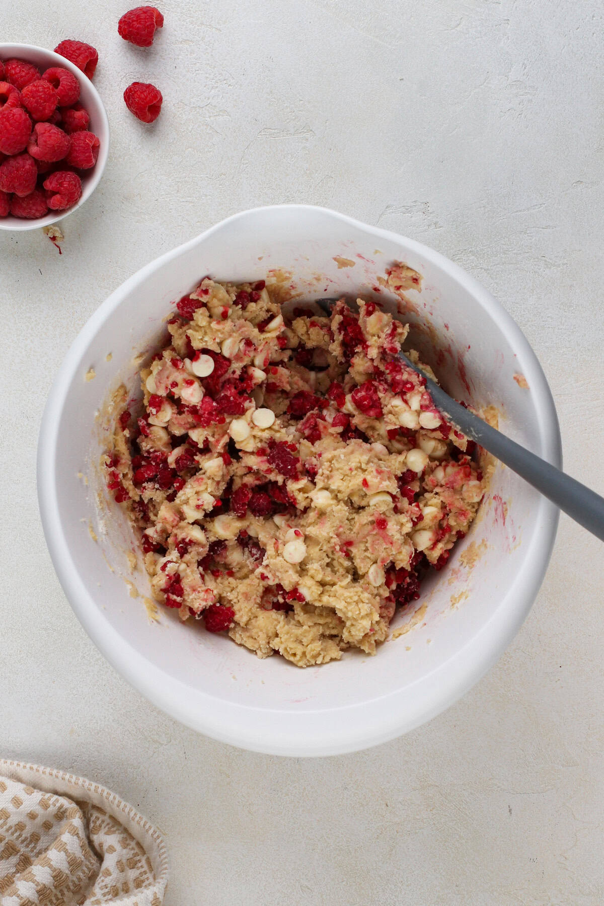 White chocolate raspberry cookie dough in a white mixing bowl.