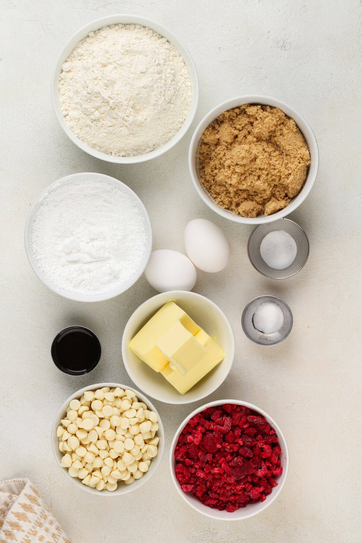 White chocolate raspberry cookie ingredients arranged on a countertop.