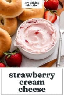 Close up of a white bowl of strawberry cream cheese surrounded by bagels. Text overlay includes recipe name.