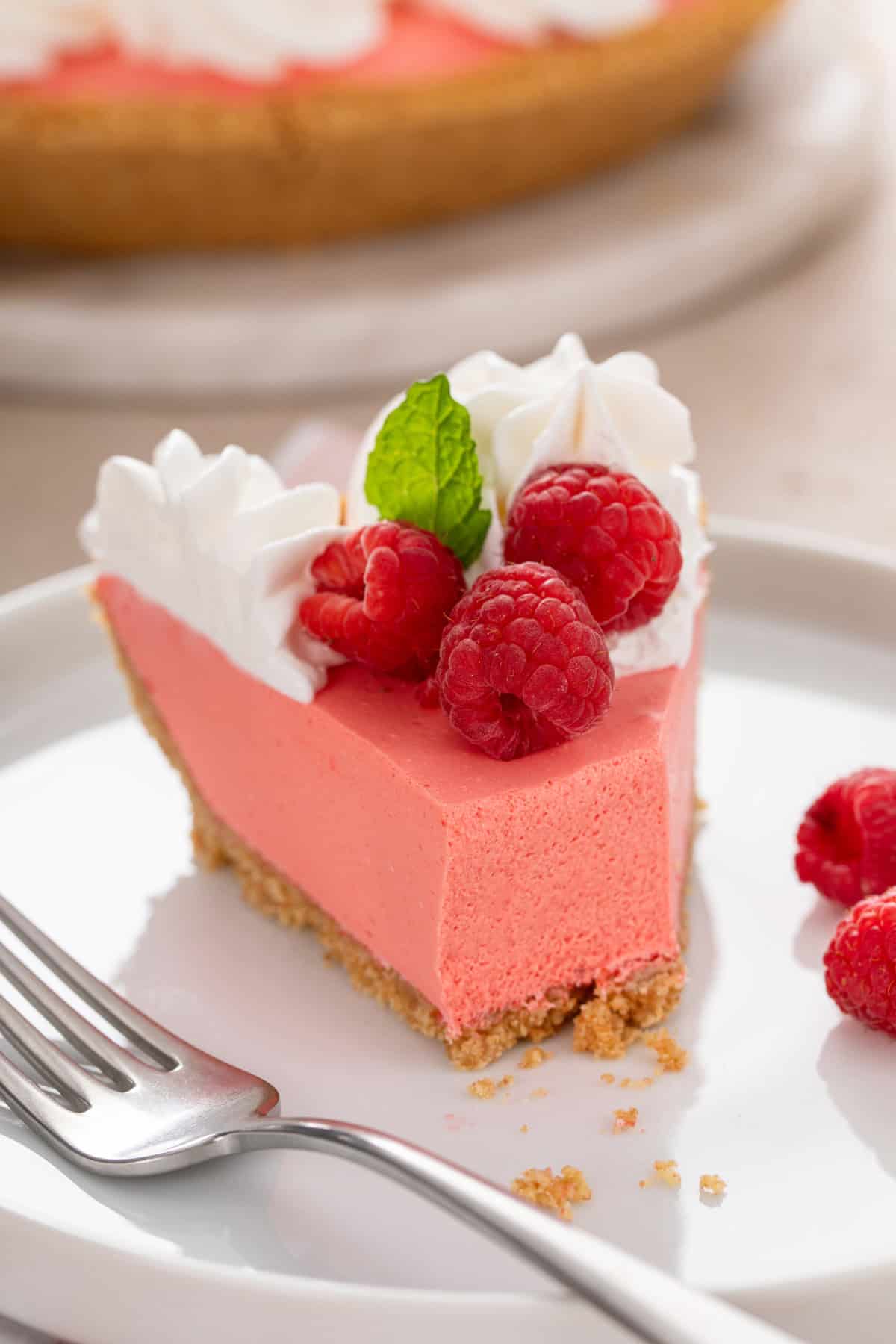 Slice of jello pie on a white plate with bites taken from the slice.