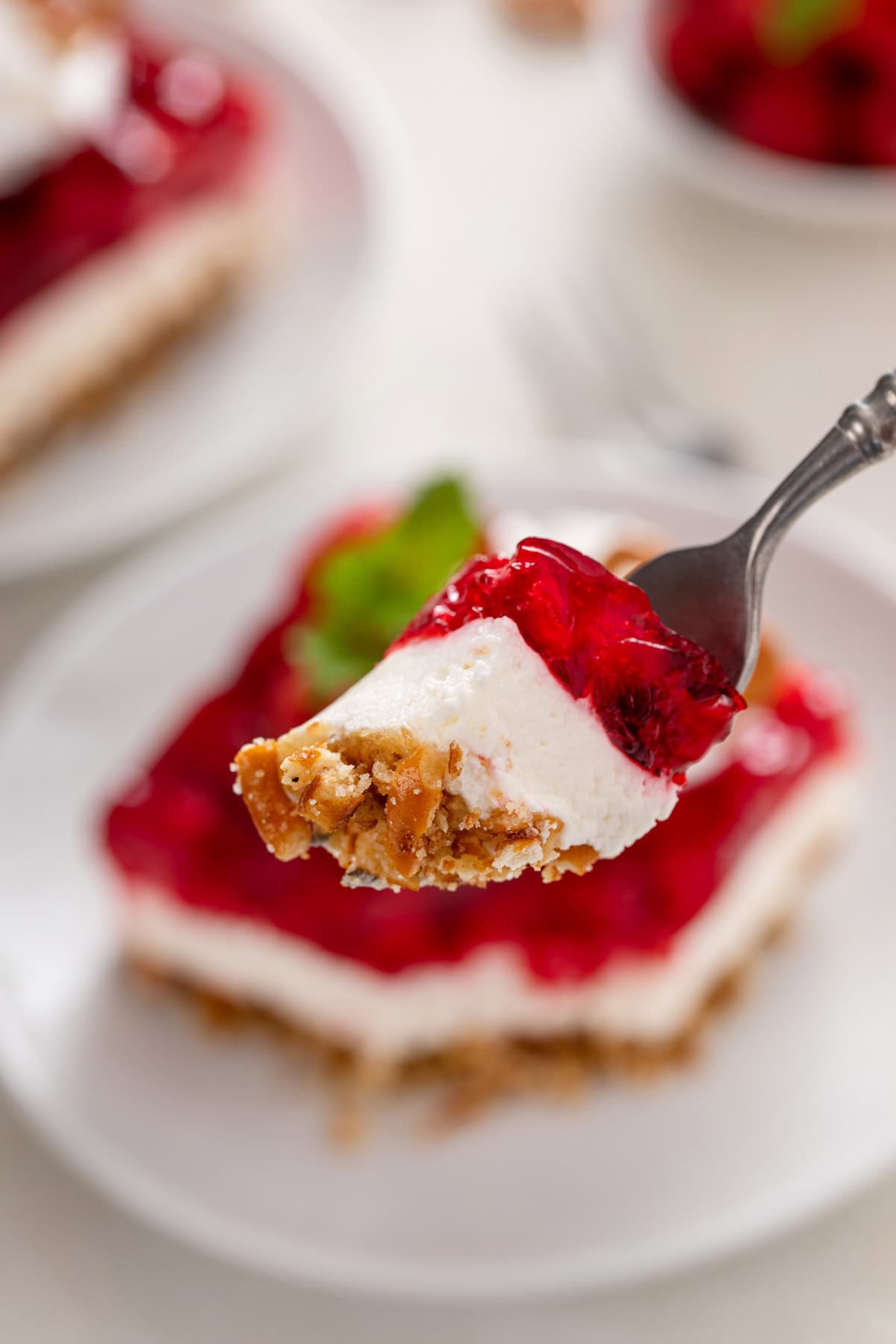 Bite from raspberry pretzel salad on a fork.