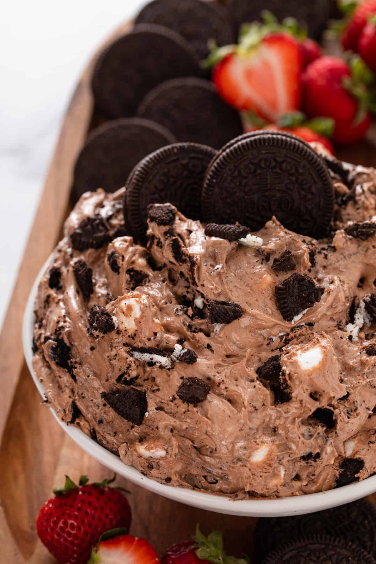 Close up of oreo fluff in a white serving bowl, garnished with whole oreos.