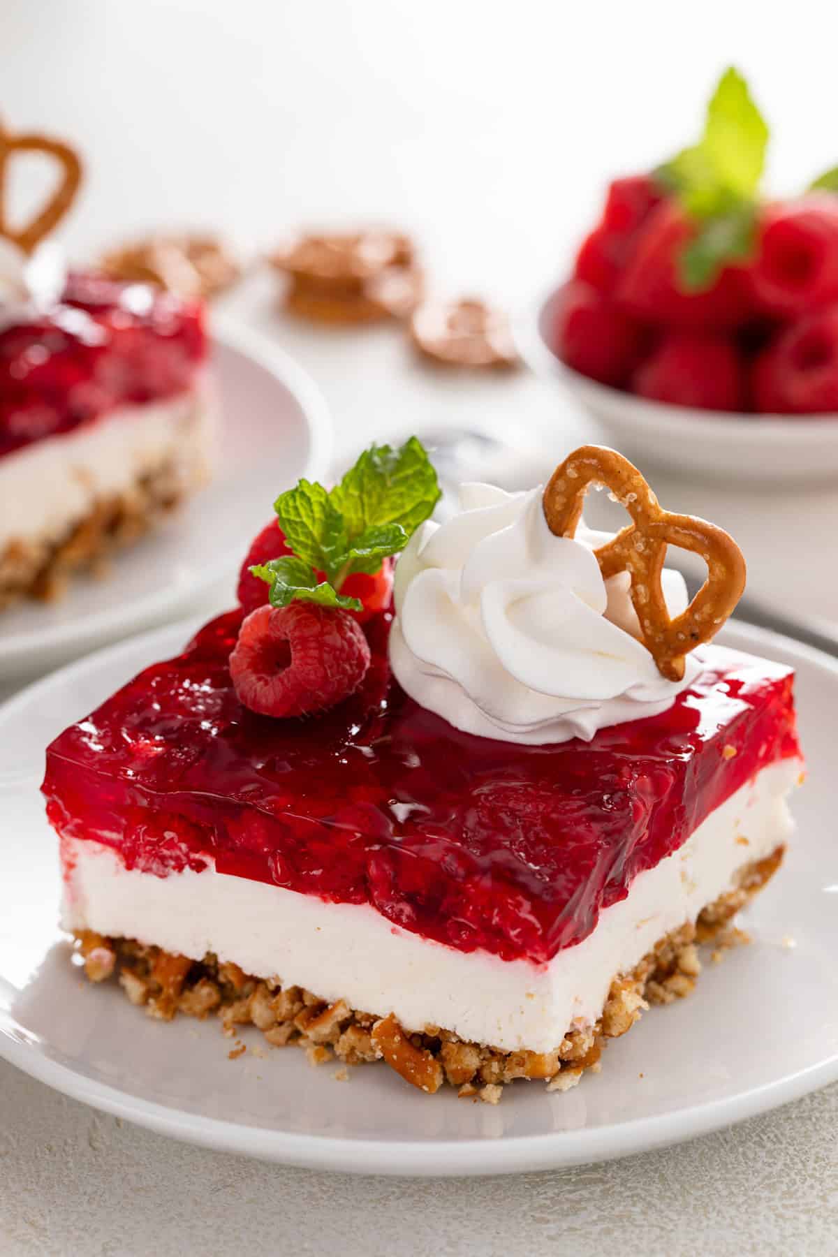 Close up of raspberry pretzel salad on a white baking dish.