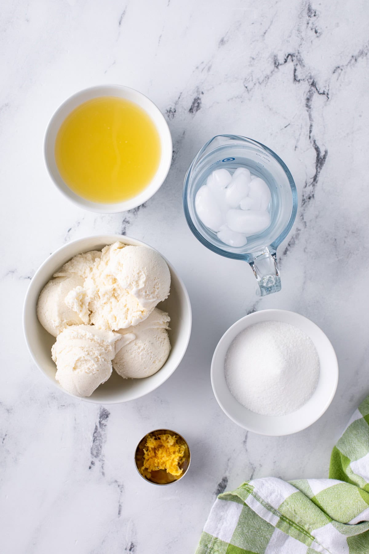 Ingredients for frosted lemonade arranged on a marble countertop.