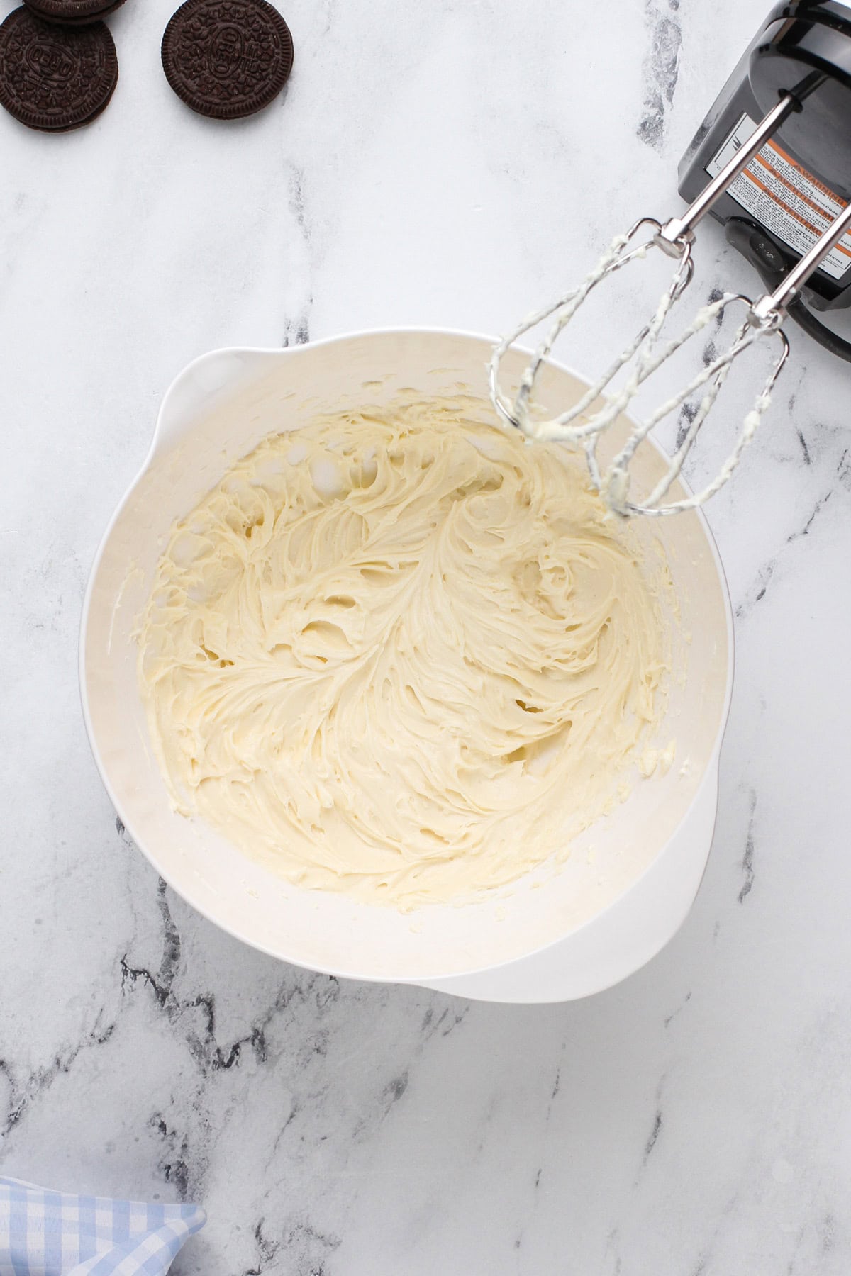 Cream cheese and sugar beaten in a white bowl.