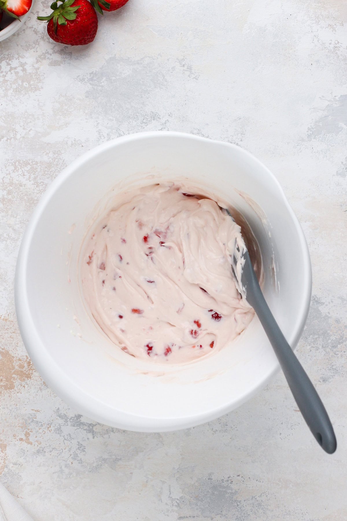 Mixed strawberry cream cheese in a white bowl.