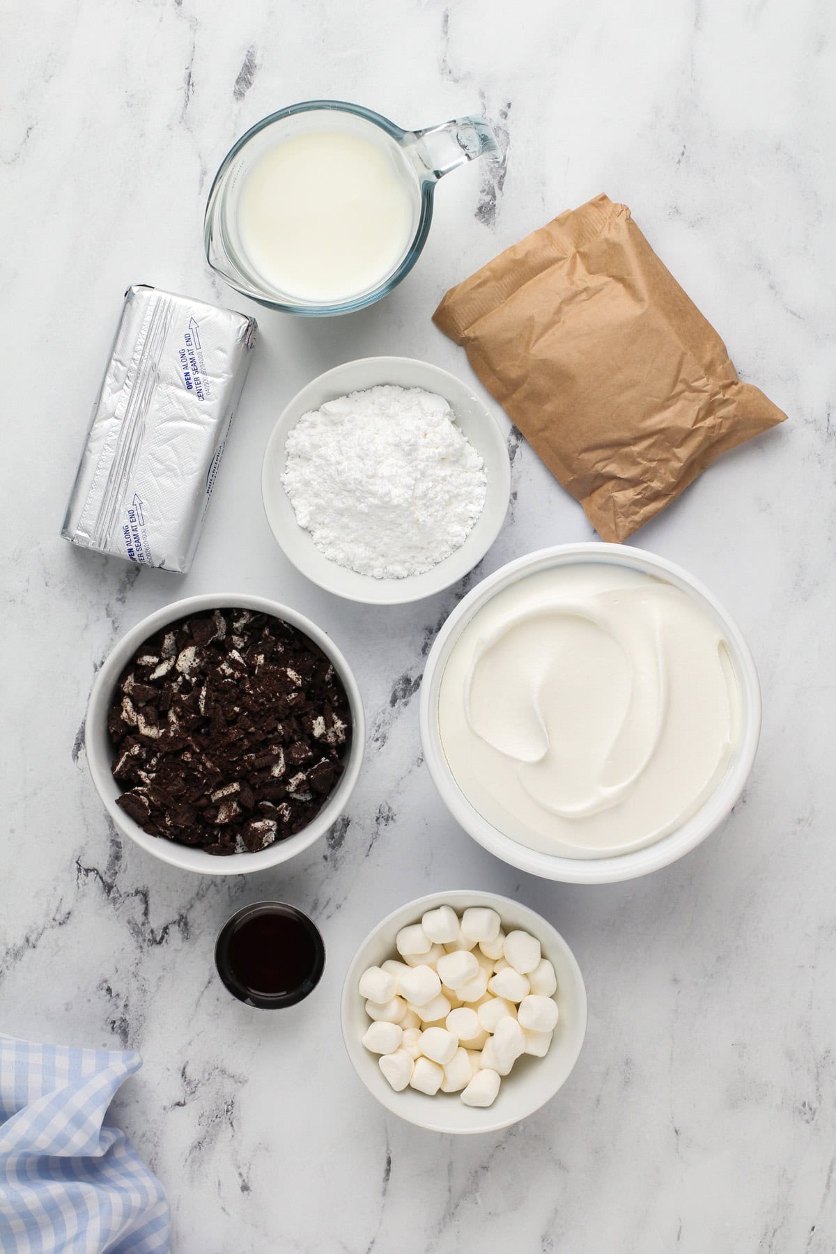 Ingredients for oreo fluff arranged on a marble countertop.
