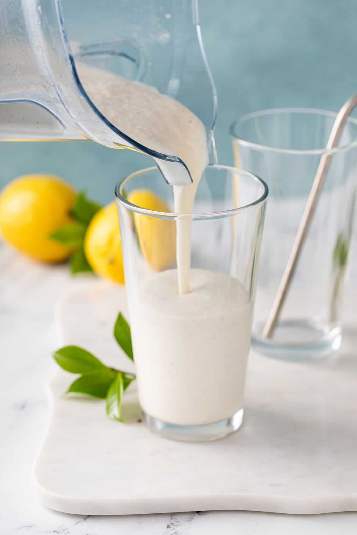 Frosted lemonade being poured into glasses.