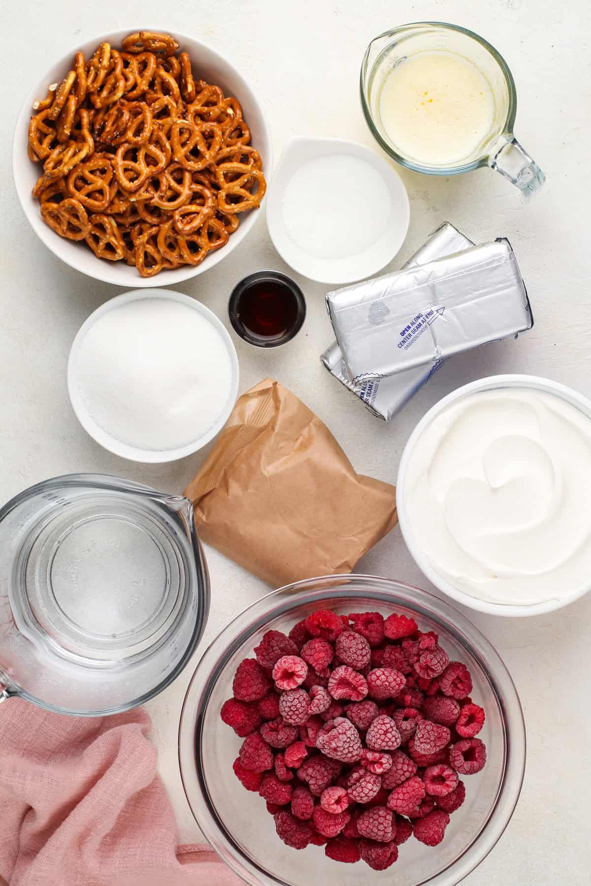 Ingredients for raspberry pretzel salad arranged on a countertop.