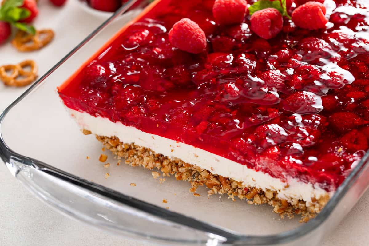 Sliced raspberry pretzel salad in a glass baking dish.