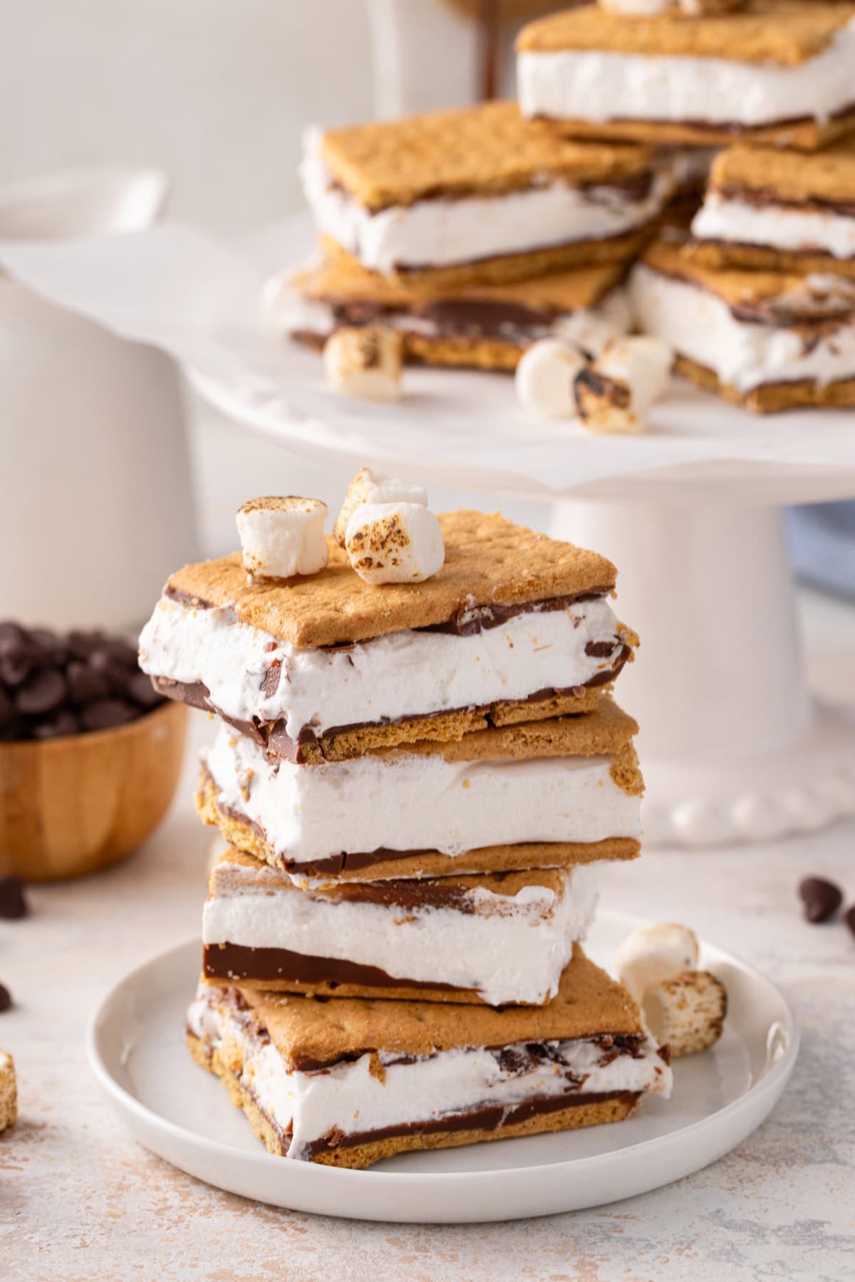 Four frozen s'mores stacked on a white plate.