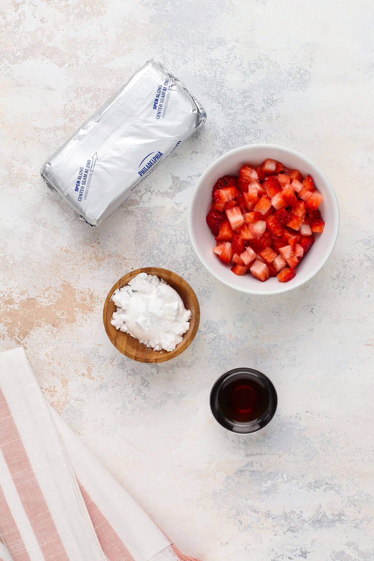 Strawberry cream cheese ingredients arranged on a countertop.