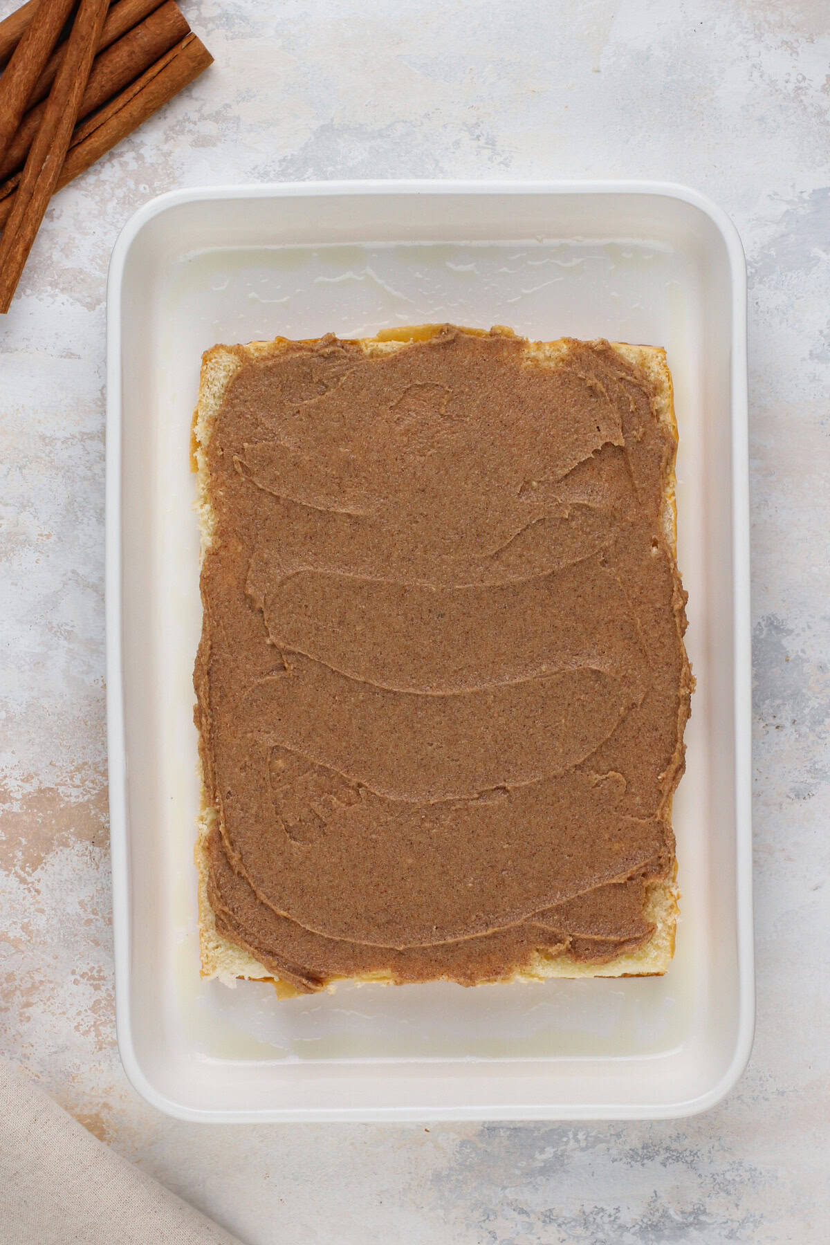Sliced hawaiian rolls spread with cinnamon butter.