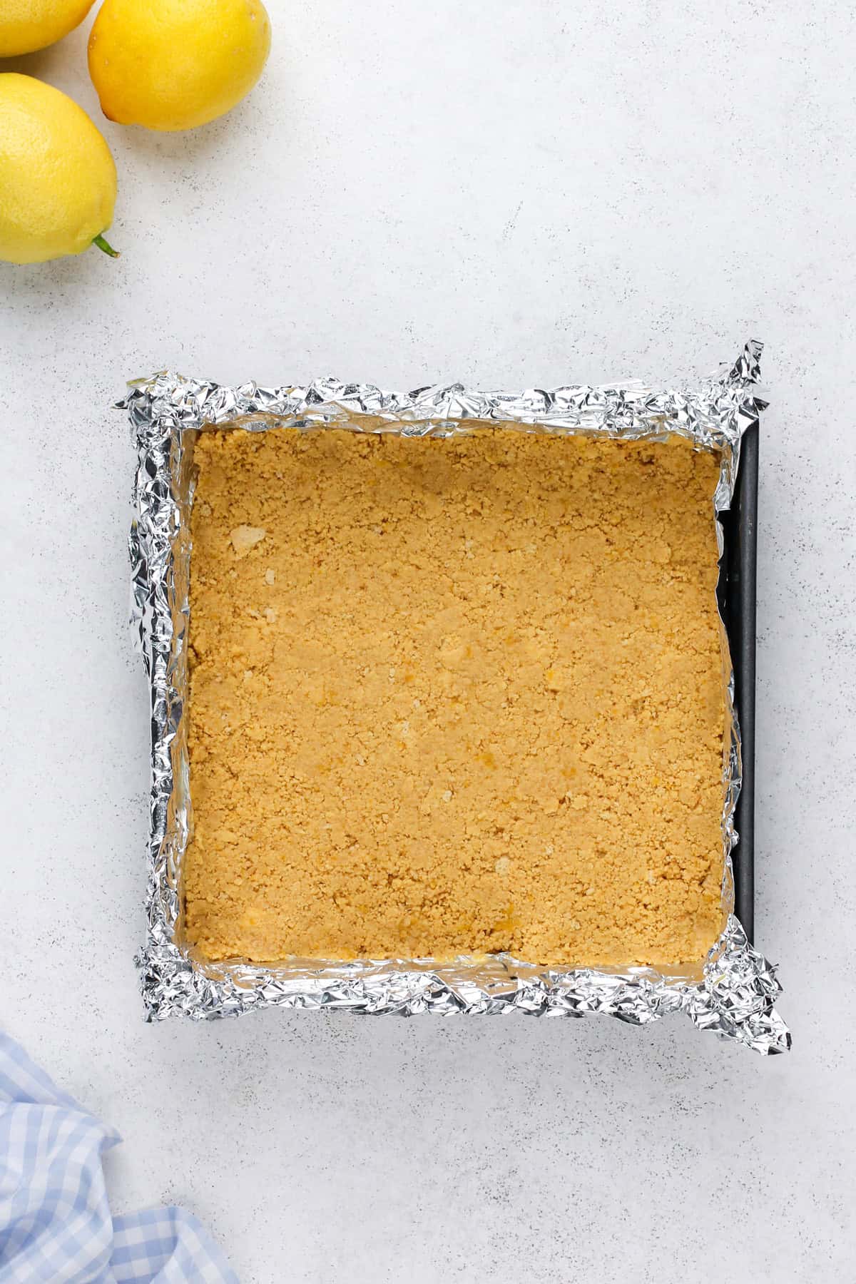 Cookie crust pressed into the bottom of a foil-lined pan.