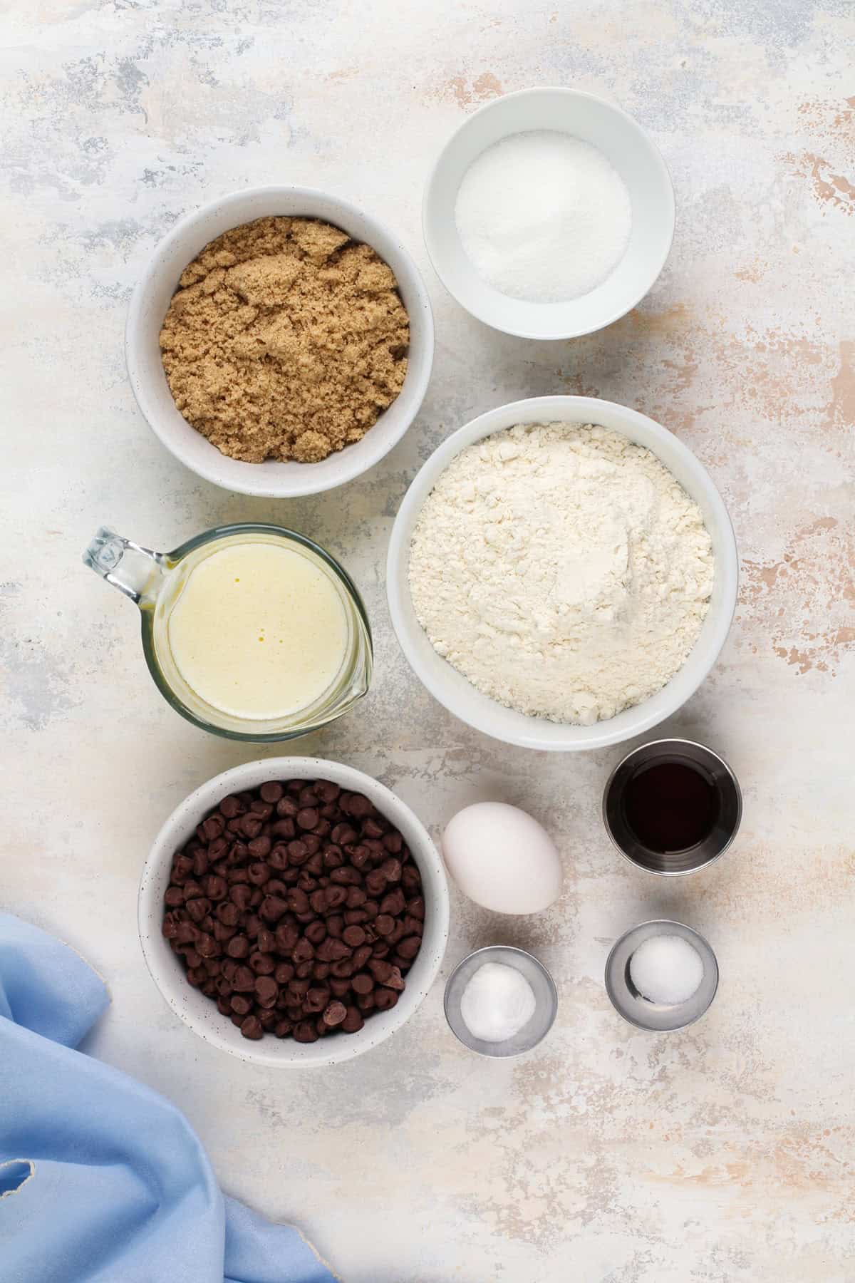 Ingredients for chocolate chip cookie cake arranged on a countertop.