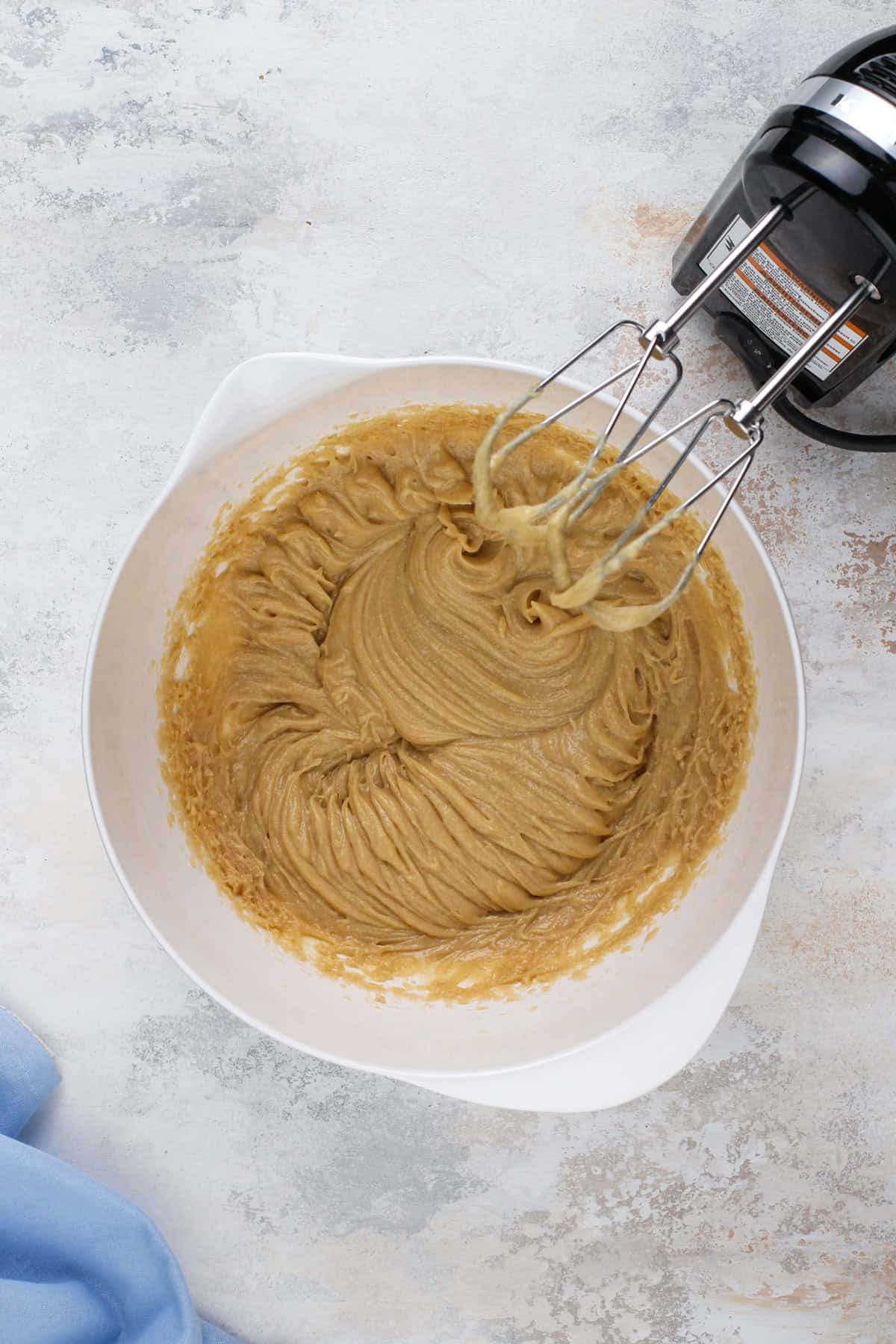 Wet ingredients for chocolate chip cookie cake mixed in a white bowl.