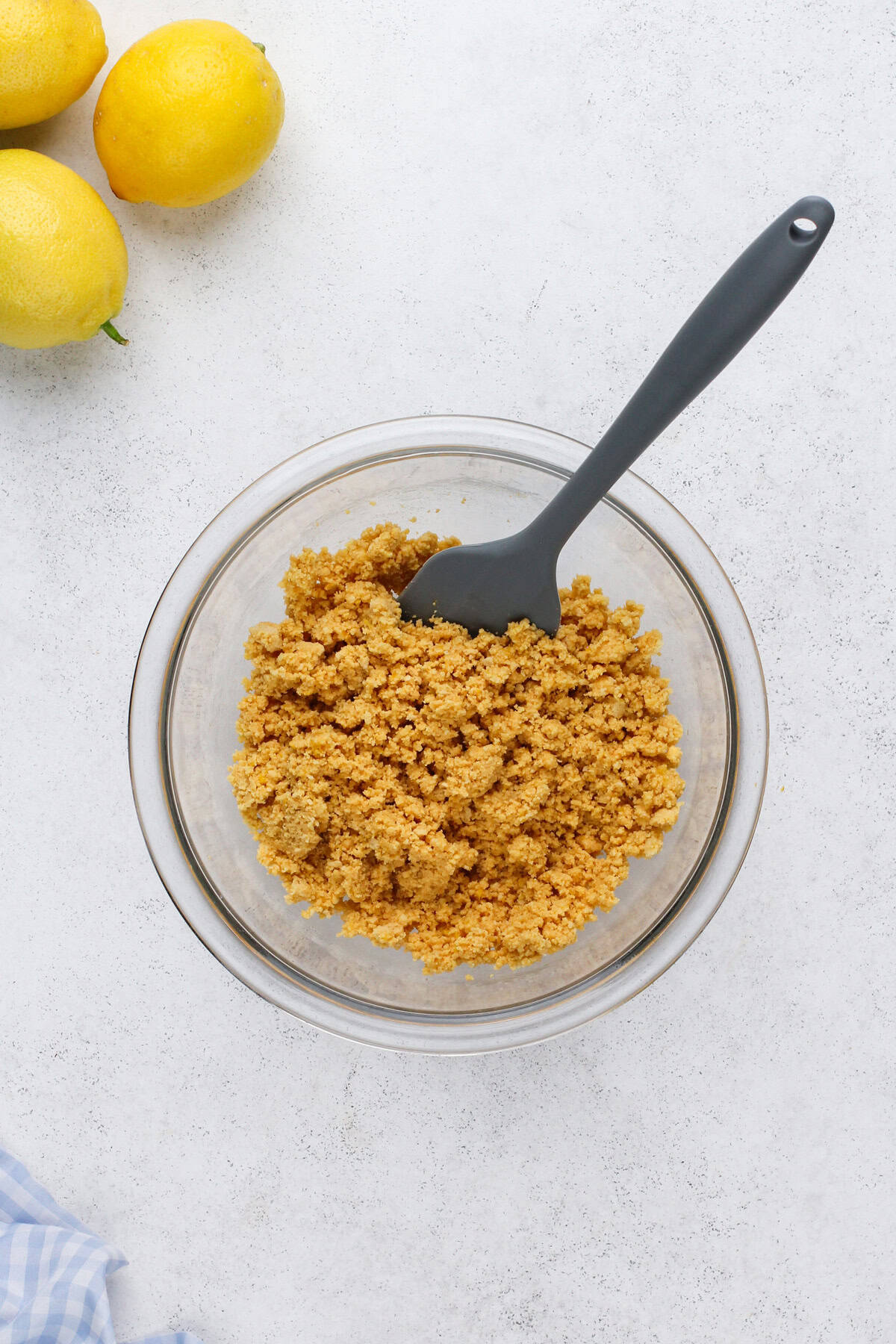 Cookie crumbs mixed with butter in a glass bowl.