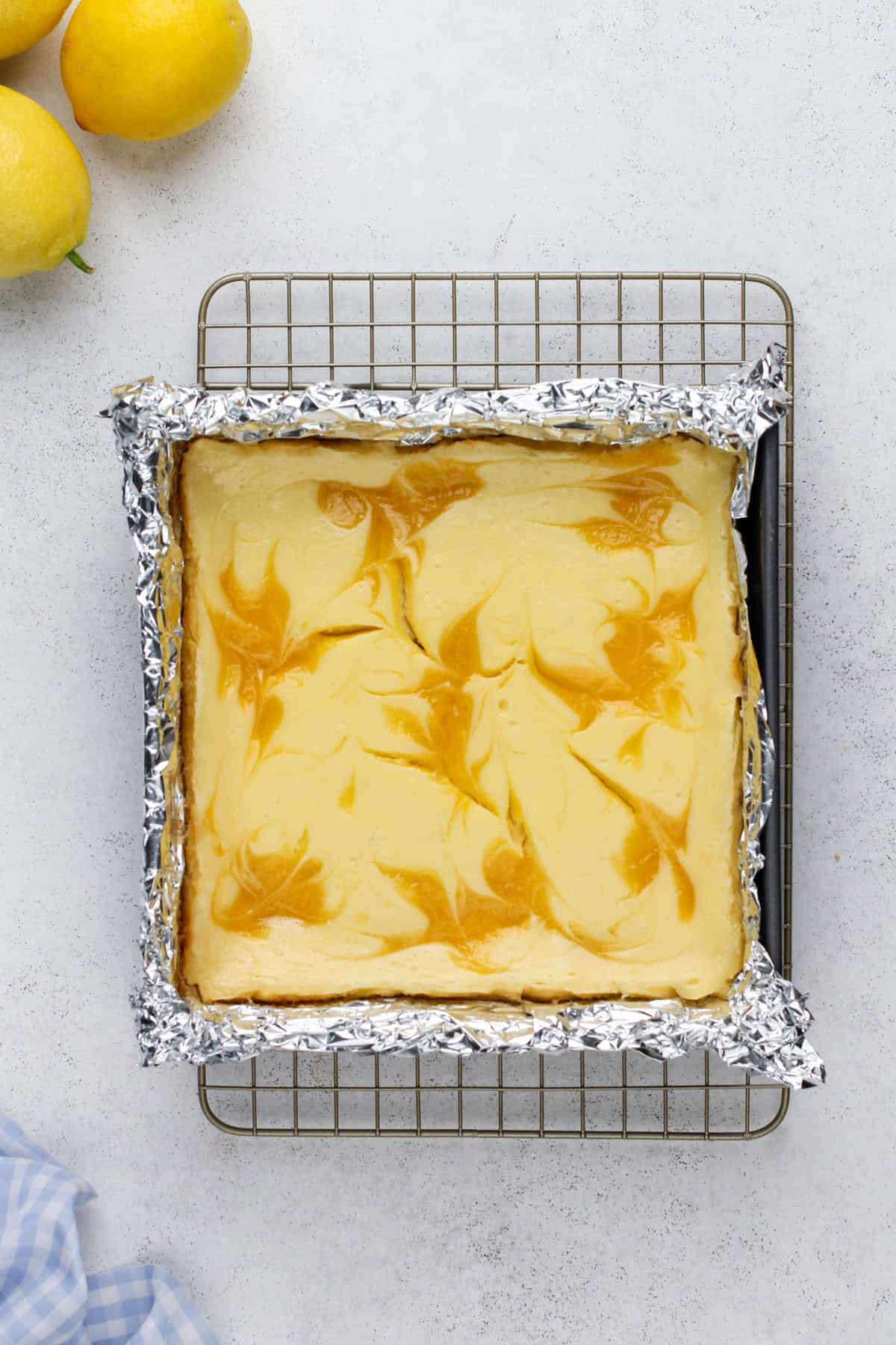 Baked lemon cheesecake bars cooling on a wire rack.