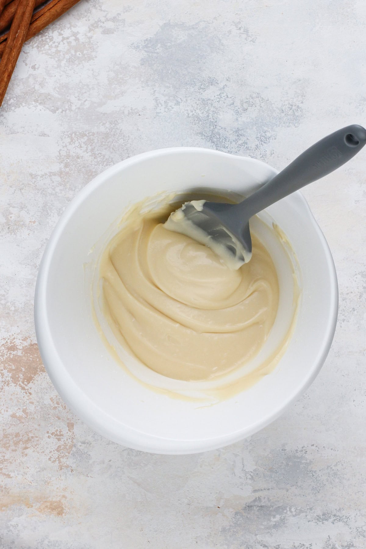 Cream cheese frosting mixed in a white bowl.