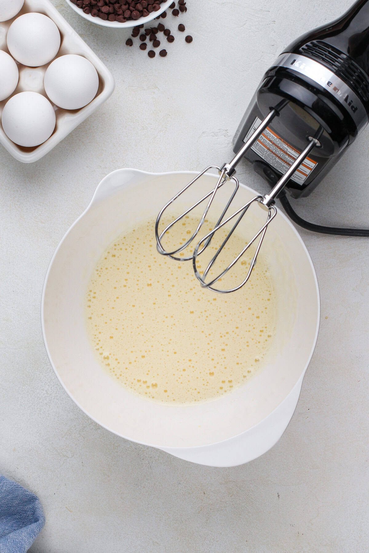 Frothy beaten eggs in a white bowl.