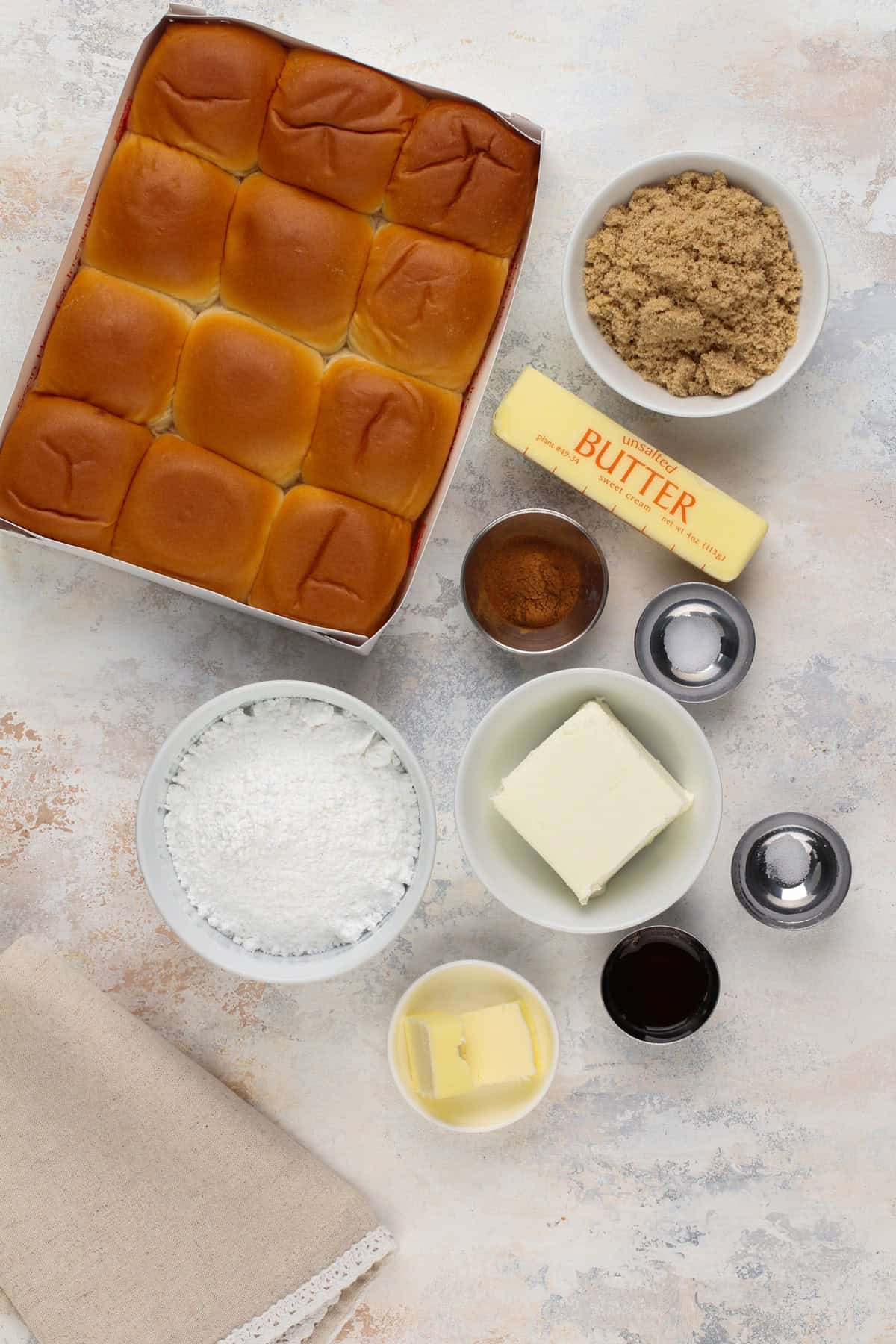 Hawaiian roll cinnamon roll ingredients arranged on a countertop.