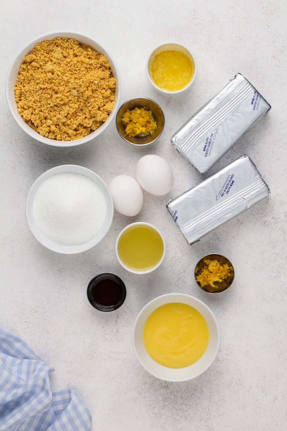 Ingredients for lemon cheesecake bars arranged on a countertop.