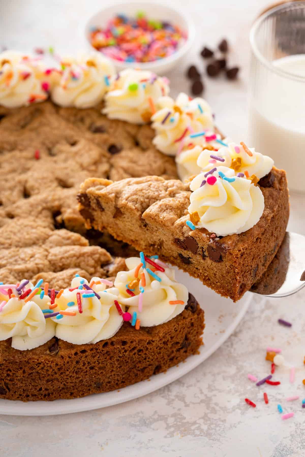 Cake server lifting up a slice of chocolate chip cookie cake.