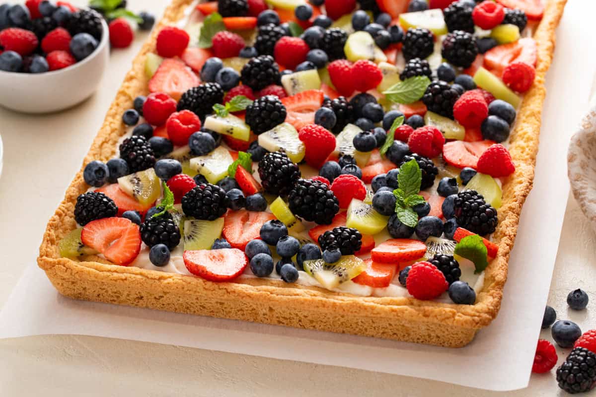 Assembled fruit pizza on a piece of parchment paper.