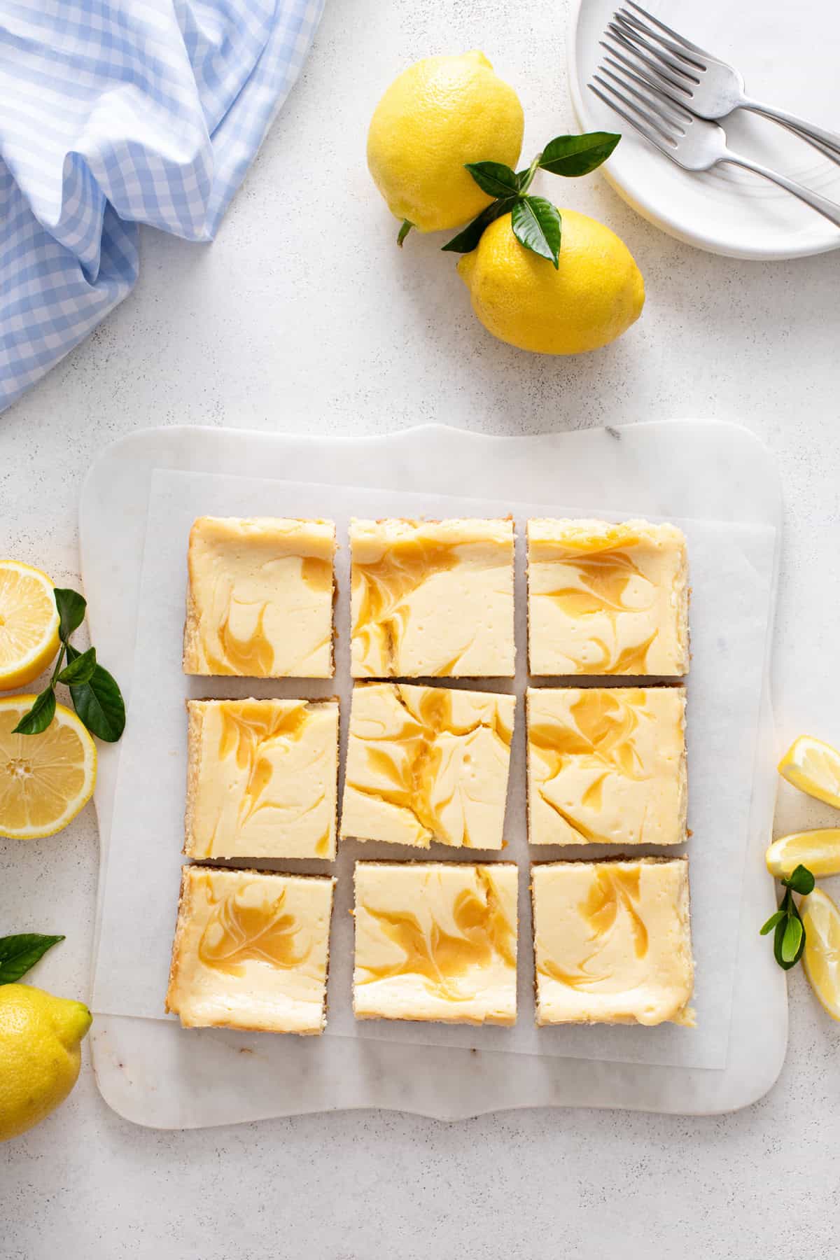 Overhead view of sliced lemon cheesecake bars on a marble board.
