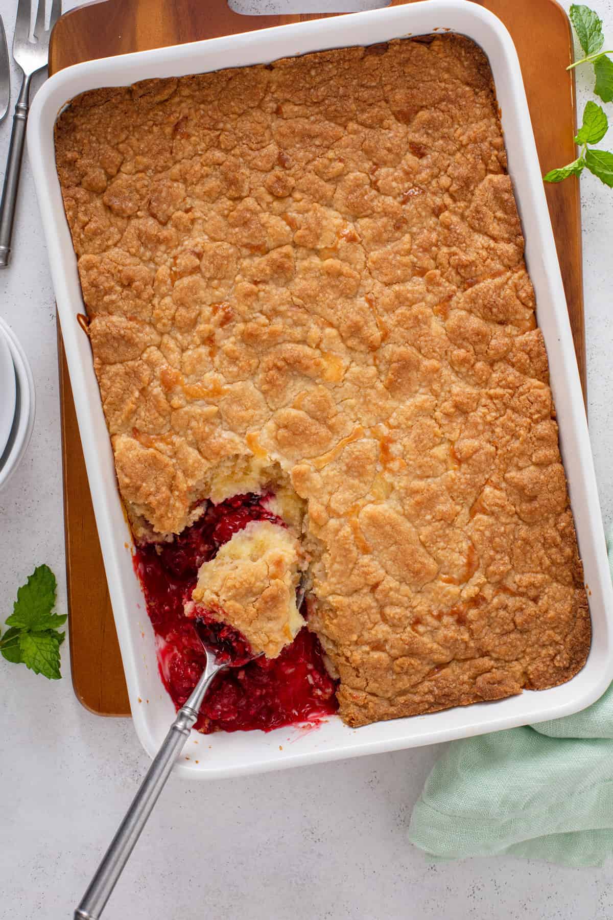 Overhead view of baked and cooled cherry cheesecake cake in a baking dish.