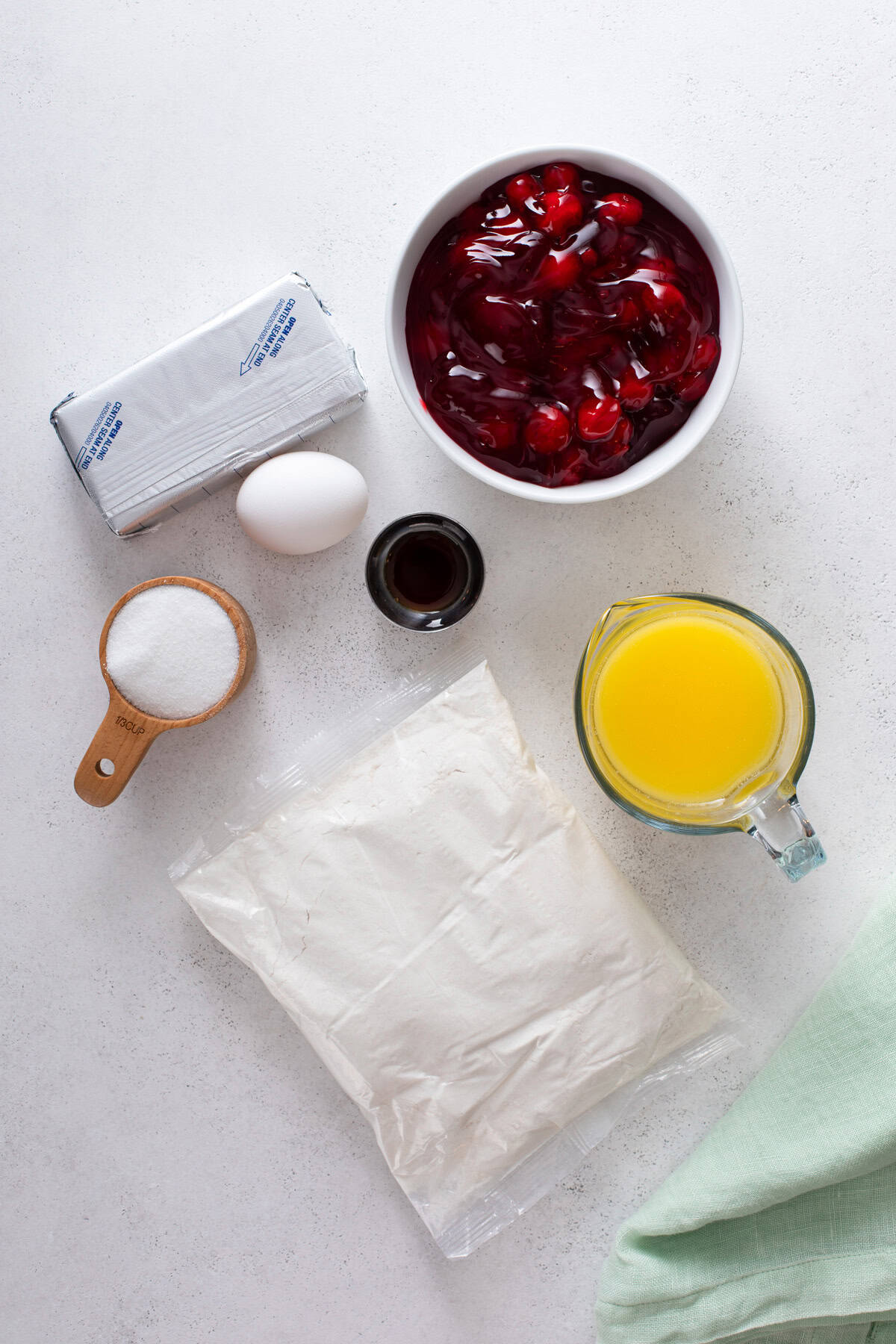 Ingredients for cherry cheesecake cake arranged on a countertop.
