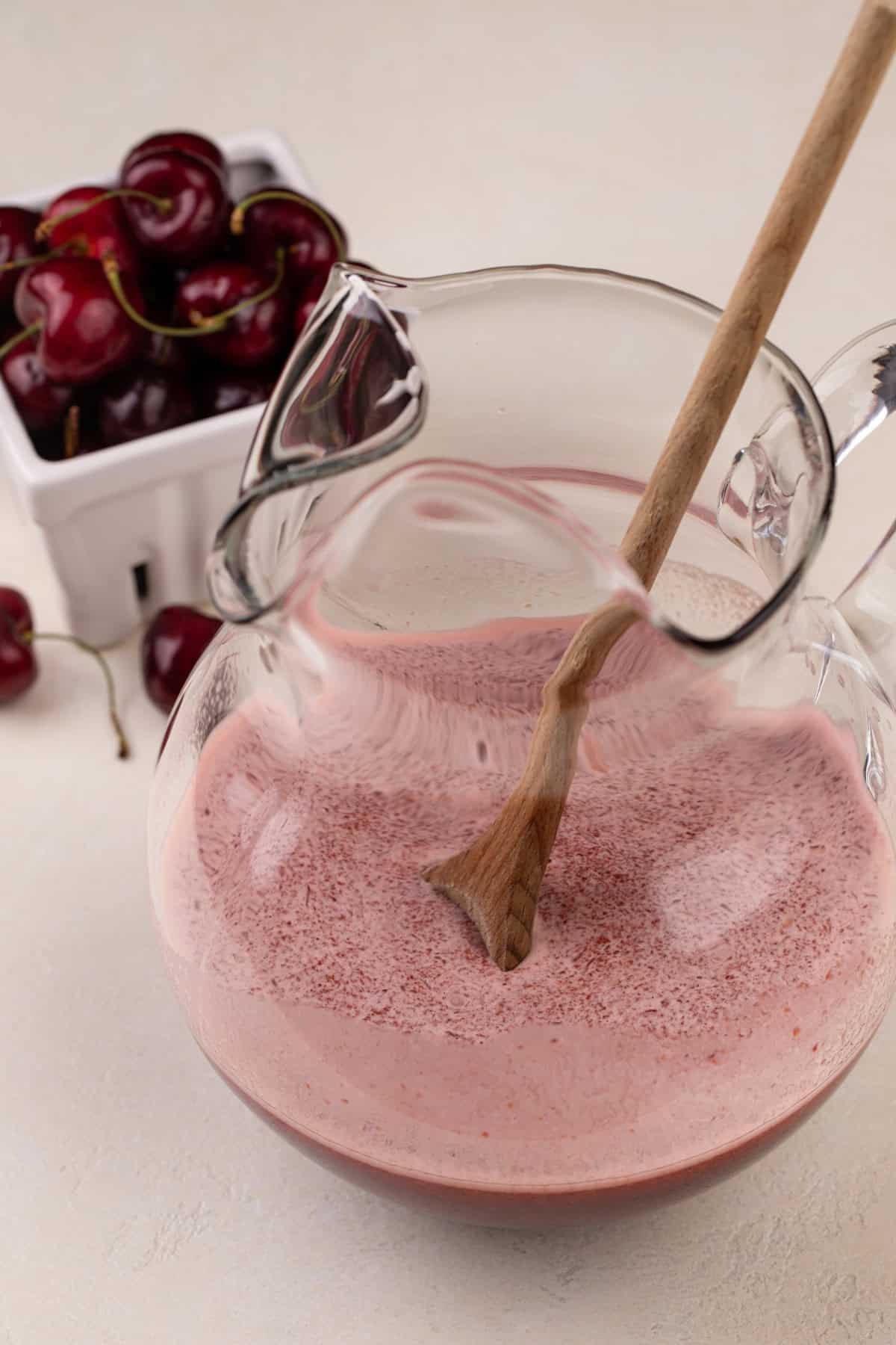 Cherry limeade base mixed in a glass pitcher.